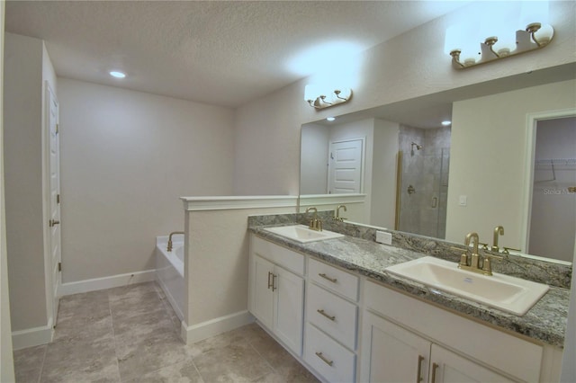 bathroom featuring vanity, a textured ceiling, and separate shower and tub