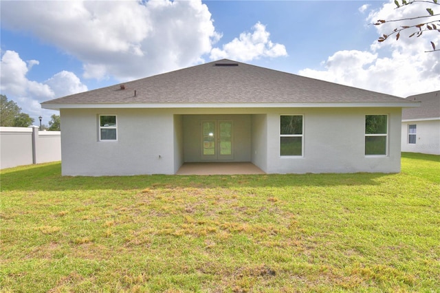 rear view of house featuring french doors, a patio area, and a lawn