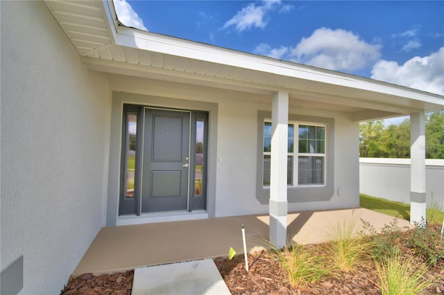 view of exterior entry with a porch