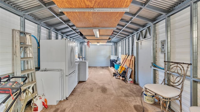 basement featuring washer / dryer and white refrigerator