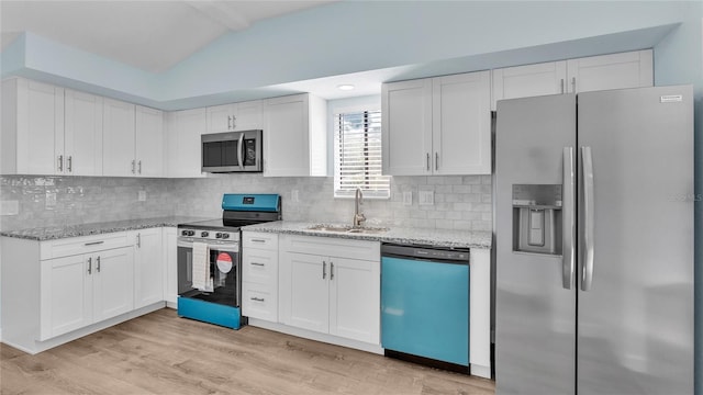 kitchen with white cabinetry, lofted ceiling, sink, decorative backsplash, and stainless steel appliances