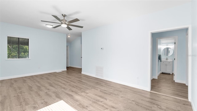 spare room featuring sink, vaulted ceiling, light hardwood / wood-style floors, and ceiling fan