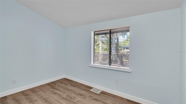 unfurnished room with light hardwood / wood-style flooring and vaulted ceiling