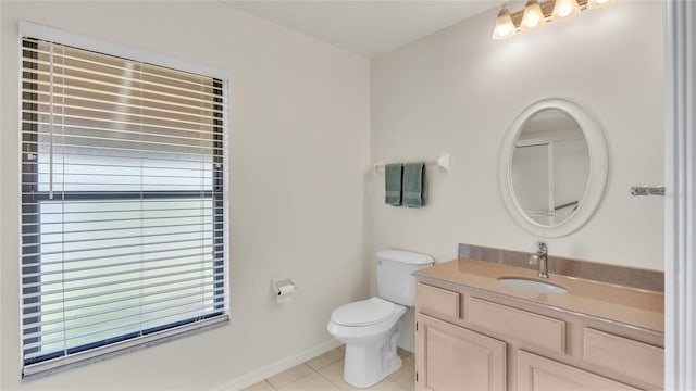 bathroom with toilet, vanity, and tile patterned floors