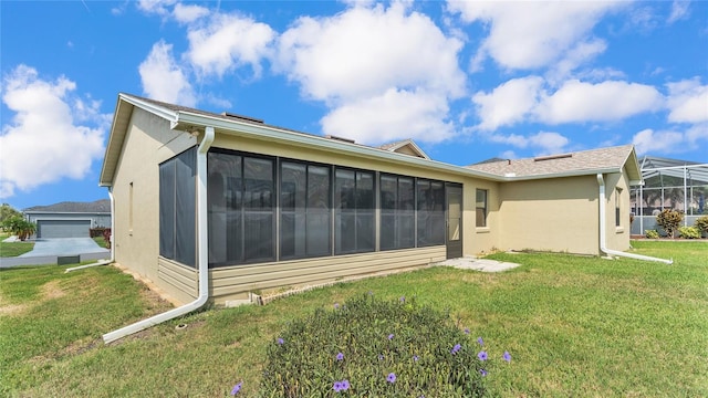 back of property featuring a sunroom and a yard