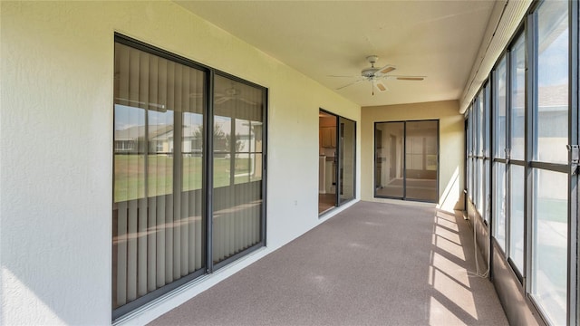 unfurnished sunroom featuring ceiling fan and plenty of natural light