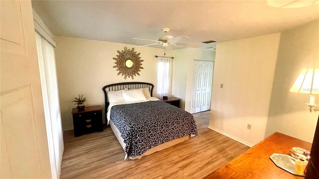 bedroom featuring ceiling fan, a closet, and wood-type flooring