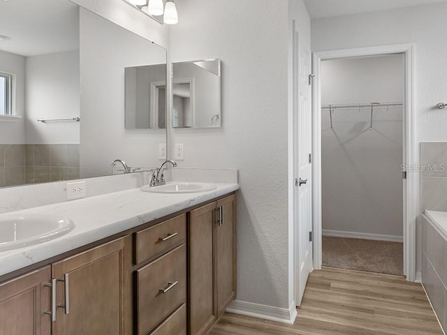 bathroom featuring a tub, hardwood / wood-style floors, and vanity