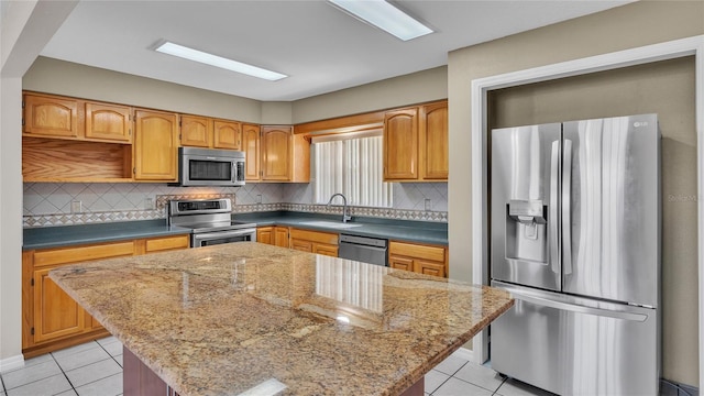 6110 Downing St, Dover, FL 33527 - kitchen featuring stainless steel appliances, light tile patterned floors, a center island, and backsplash