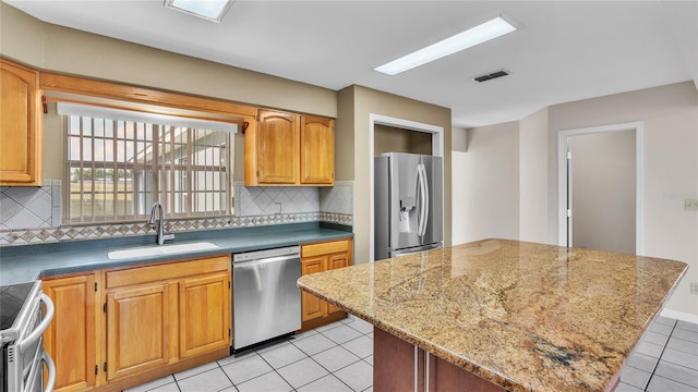 6110 Downing St, Dover, FL 33527 - kitchen with appliances with stainless steel finishes, light tile patterned floors, tasteful backsplash, a kitchen island, and light stone counters
