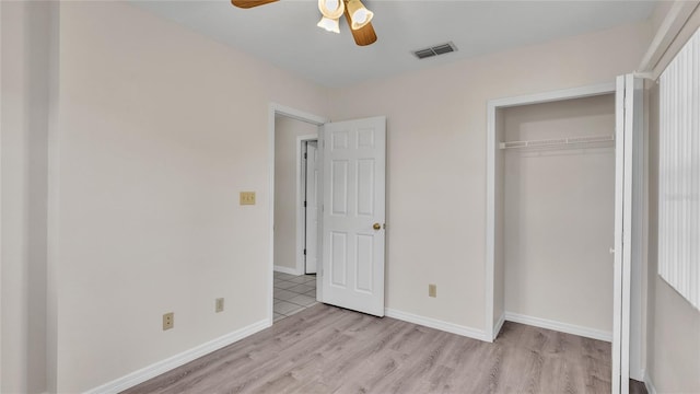 unfurnished bedroom featuring ceiling fan, a closet, and light hardwood / wood-style flooring