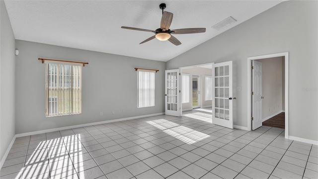 spare room with ceiling fan, french doors, high vaulted ceiling, a textured ceiling, and light tile patterned flooring