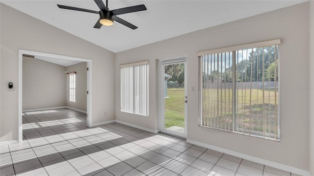 tiled spare room with plenty of natural light, ceiling fan, and lofted ceiling