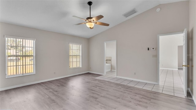 unfurnished room with a wealth of natural light, lofted ceiling, and light wood-type flooring