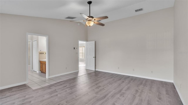 unfurnished bedroom with ensuite bathroom, high vaulted ceiling, ceiling fan, and light hardwood / wood-style floors