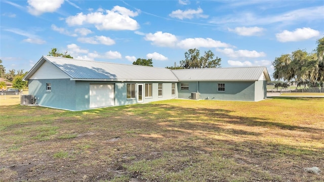 back of house featuring a lawn and central air condition unit