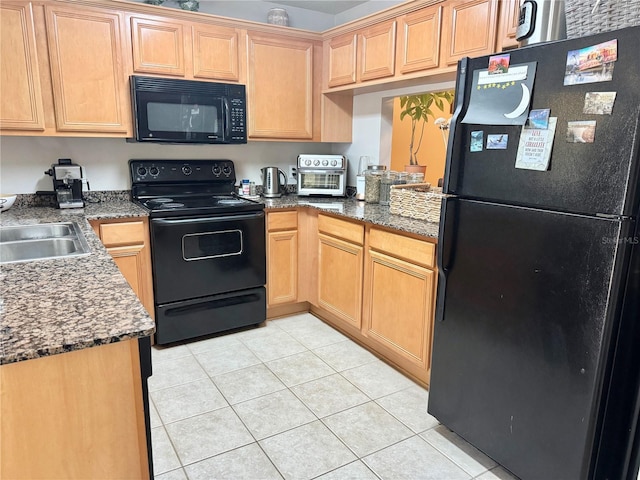 kitchen featuring light tile patterned floors, sink, dark stone counters, and black appliances