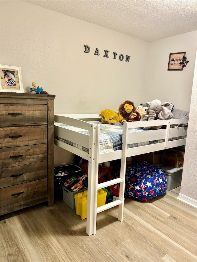 bedroom with hardwood / wood-style floors and a textured ceiling