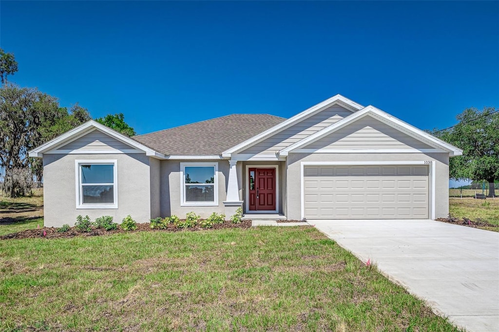 ranch-style home featuring a garage and a front lawn