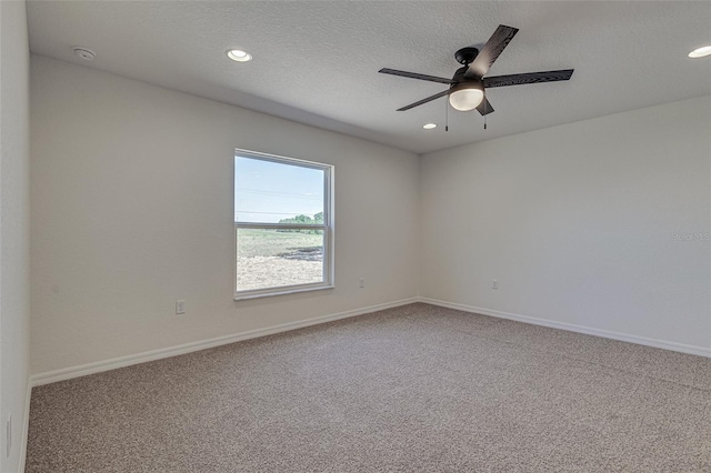 empty room with carpet, ceiling fan, and a textured ceiling