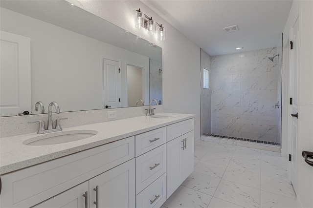 bathroom with a tile shower and vanity