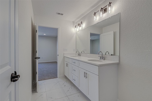 bathroom featuring a textured ceiling and vanity