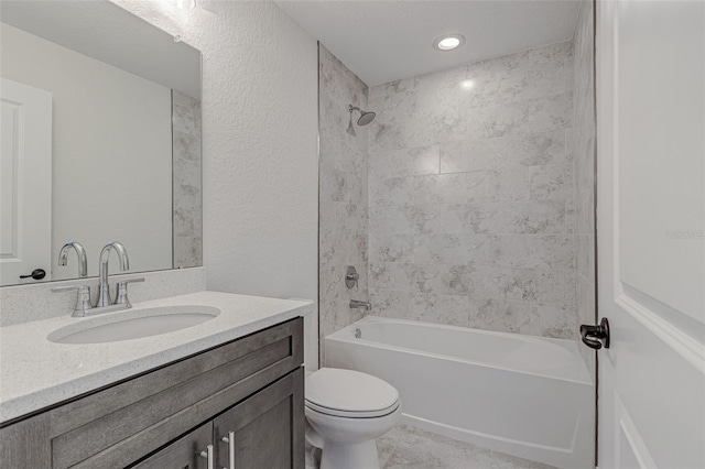 full bathroom with vanity, tiled shower / bath combo, and toilet