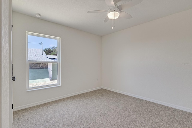 carpeted spare room with ceiling fan