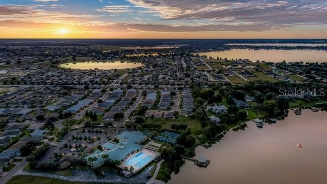 aerial view at dusk featuring a water view