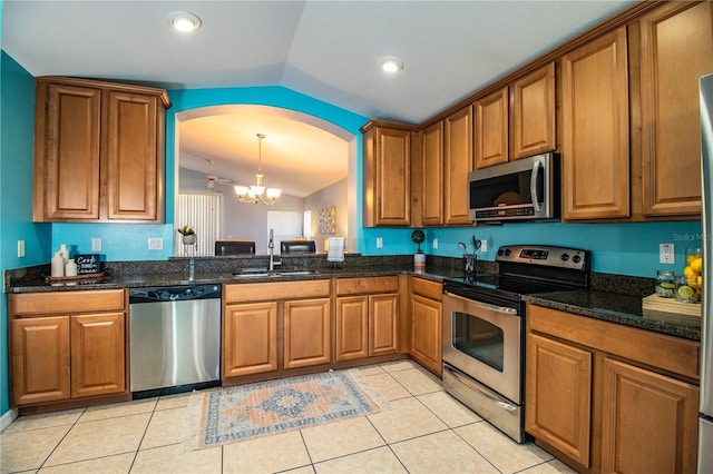 kitchen featuring lofted ceiling, sink, appliances with stainless steel finishes, decorative light fixtures, and a chandelier