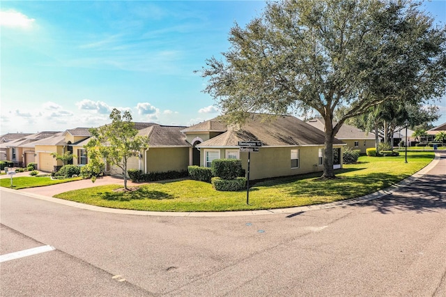 ranch-style home with a garage and a front lawn