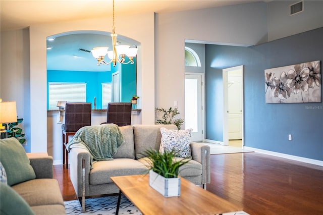 living room featuring high vaulted ceiling, hardwood / wood-style floors, and a chandelier