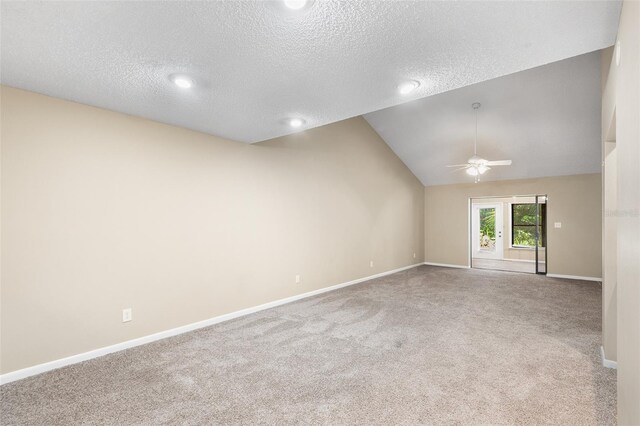 spare room featuring ceiling fan, carpet floors, a textured ceiling, and lofted ceiling