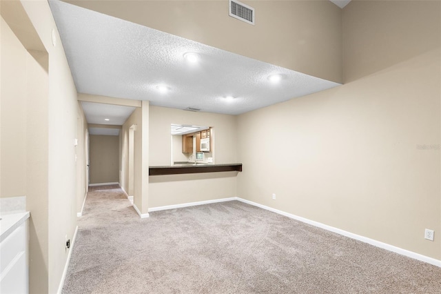 carpeted empty room featuring a textured ceiling