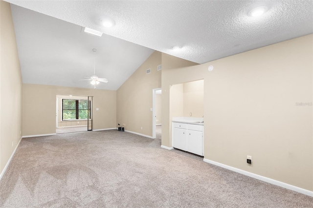 unfurnished room with light carpet, ceiling fan, lofted ceiling, and a textured ceiling