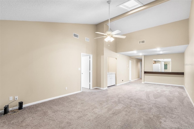 unfurnished living room featuring light carpet, a textured ceiling, high vaulted ceiling, and ceiling fan