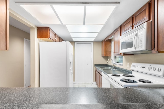 kitchen with sink, white appliances, and light tile patterned floors