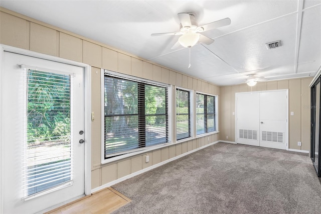 unfurnished sunroom with ceiling fan