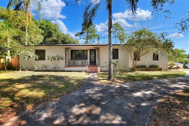 ranch-style house with covered porch and a front yard