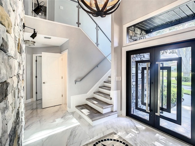 foyer entrance with a towering ceiling and french doors