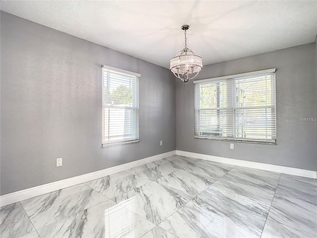 spare room featuring a notable chandelier