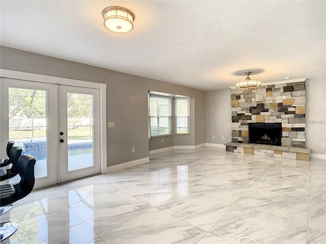 living room featuring french doors and a stone fireplace