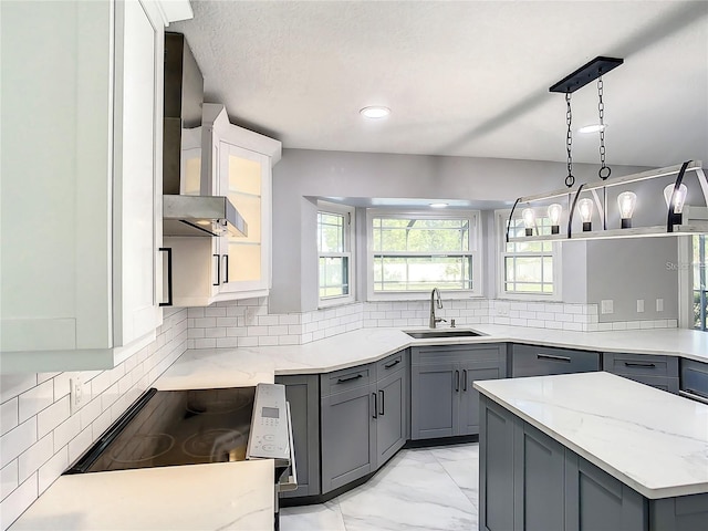 kitchen featuring tasteful backsplash, sink, hanging light fixtures, electric range, and light stone countertops
