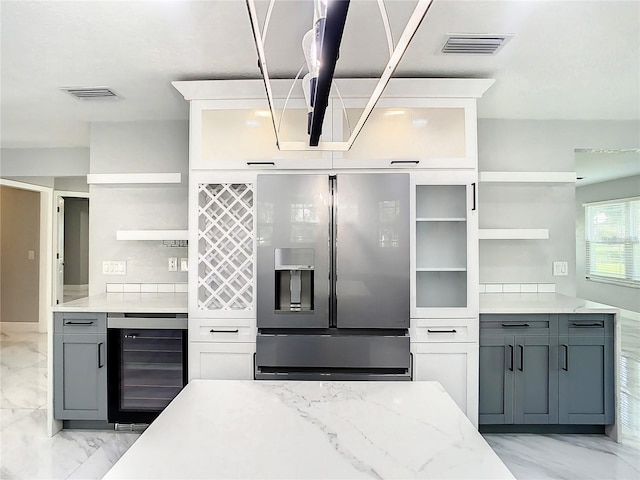 kitchen featuring gray cabinets, stainless steel fridge, beverage cooler, and white cabinets