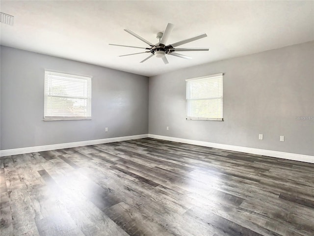 unfurnished room featuring dark hardwood / wood-style floors, a wealth of natural light, and ceiling fan