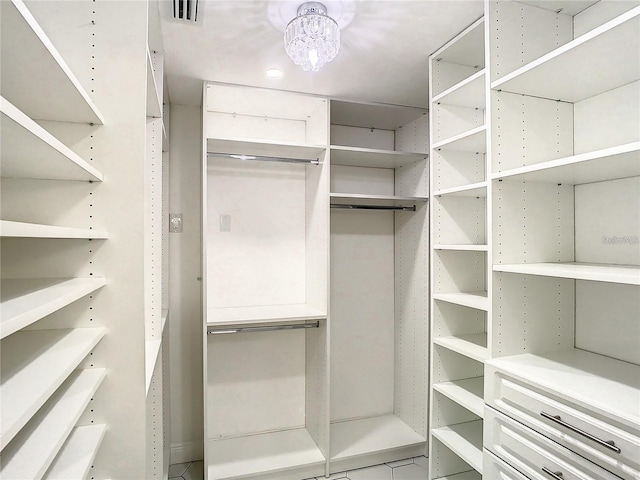 walk in closet featuring a notable chandelier