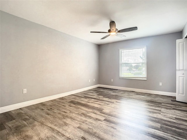 spare room with ceiling fan and dark hardwood / wood-style floors