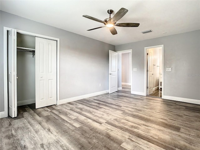 unfurnished bedroom with hardwood / wood-style floors, a closet, and ceiling fan