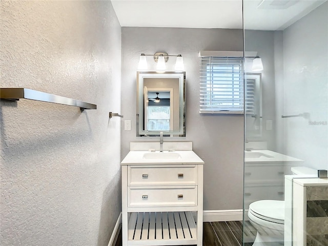 bathroom featuring vanity, toilet, and walk in shower