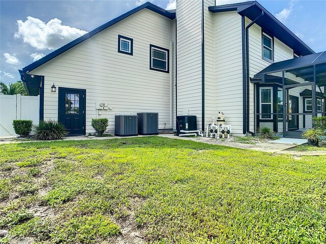 view of side of home featuring central AC unit and a lawn
